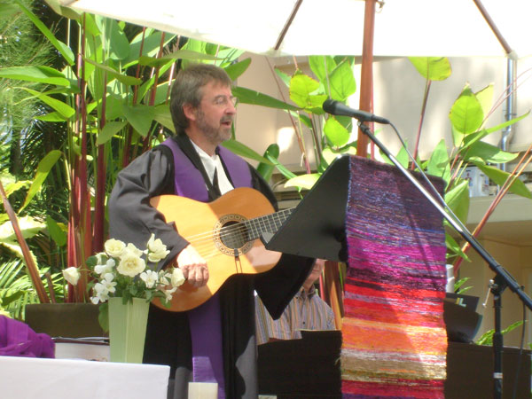 Pfarrer Bartel singt zur Gitarre im Garten der Botschaft. Der engagierte Christ hat schon einige gute Beiträge für unser Magazin gefertigt.
