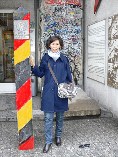 Khun Chuleepan vor einem Stück der Berliner Mauer