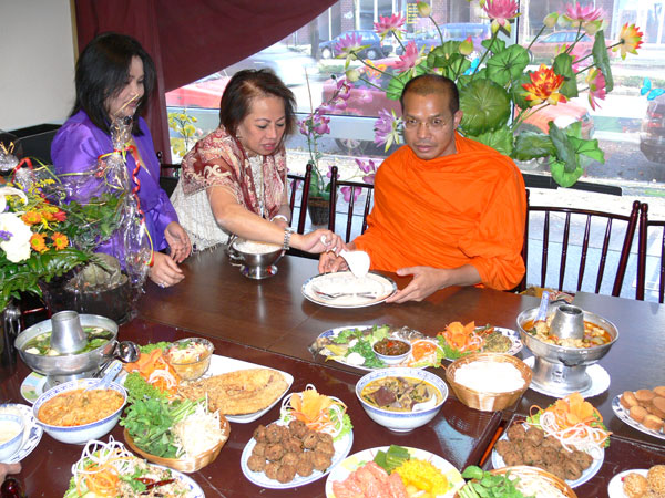Jimmy in Blau und Judy geben dem Mönch Reis und reichlich Speisen.